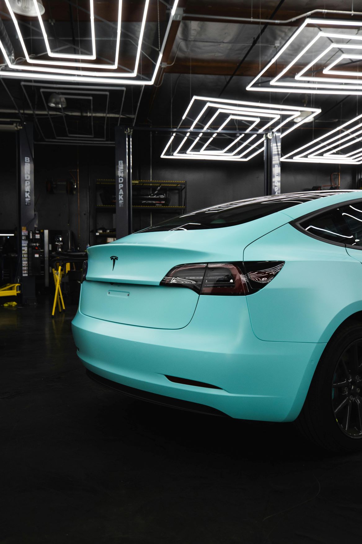 teal colored tesla with tinted windows